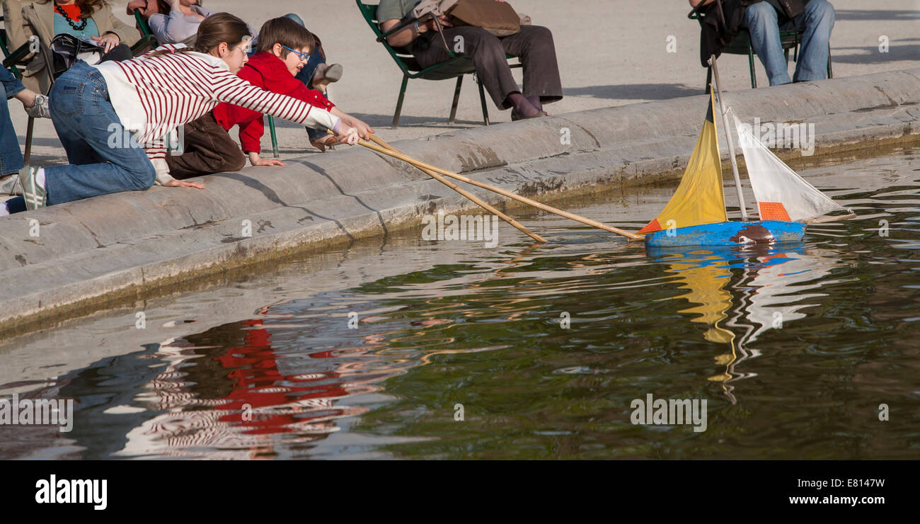 Francia, Parigi, bambini che giocano con il giocattolo in barca a vela, Giardino delle Tuileries Foto Stock