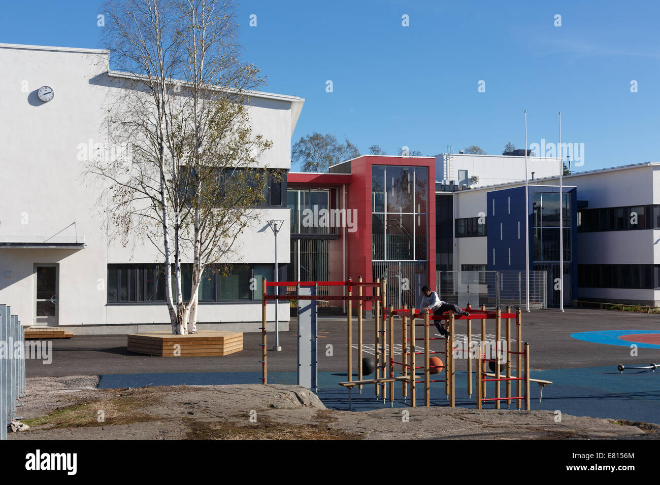Il cortile anteriore di un nuovo e moderno 2014 Helsinki Kulosaari edificio scolastico è dotato di un parco giochi per gli alunni. Foto Stock