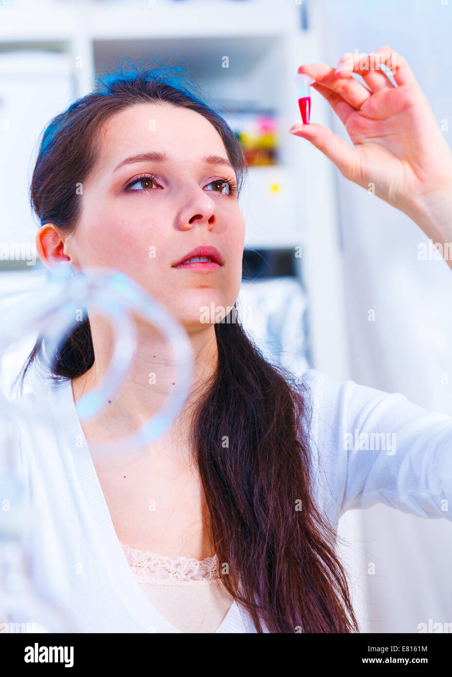 Femmina assistente di laboratorio analisi di un campione di sangue. Text il tubo con il campione biologico Foto Stock