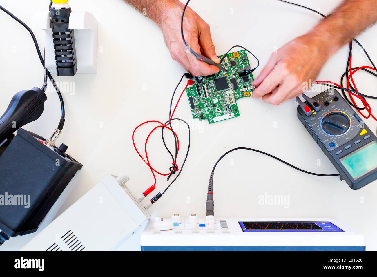 Sviluppo di dispositivi elettronici nel moderno laboratorio di elettronica, su un tavolo, il microprocessore oscilloscopio e multimetro Foto Stock