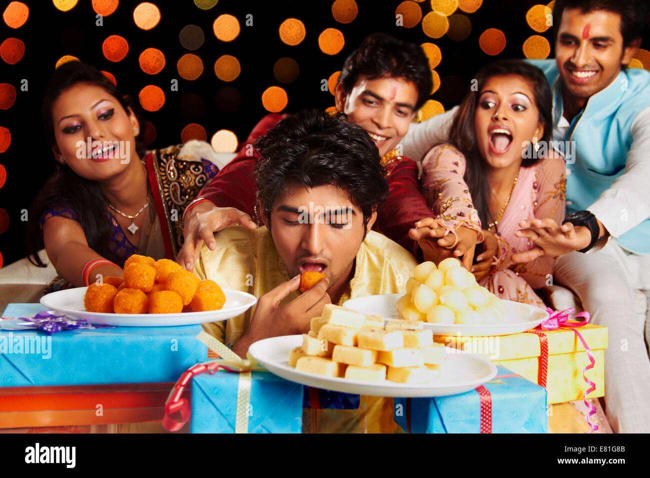 Alcuni amici indiani diwali mangiando caramelle Foto Stock