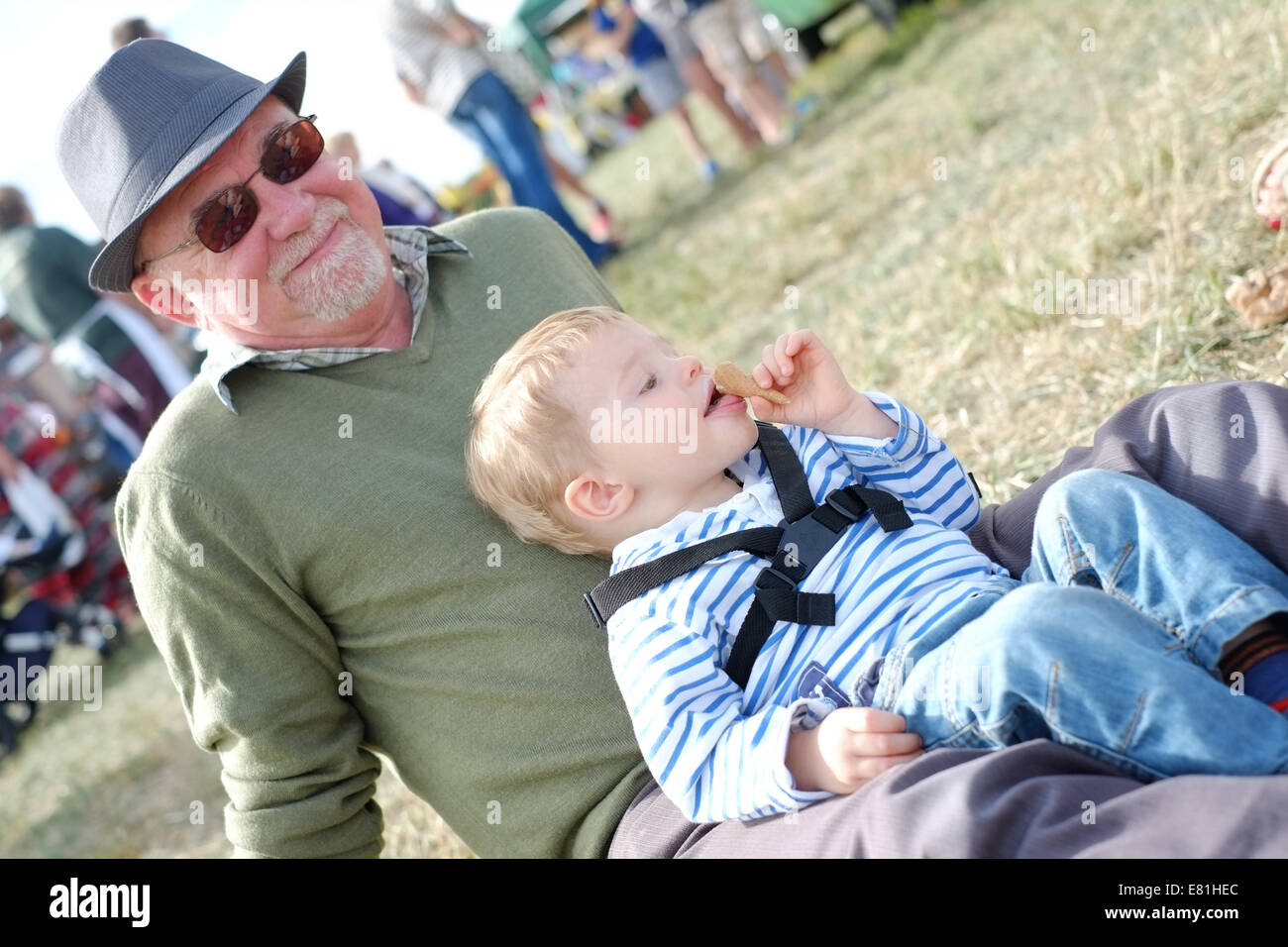 Due anni di vecchio ragazzo di mangiare un gelato mentre seduto con il suo nonno Foto Stock