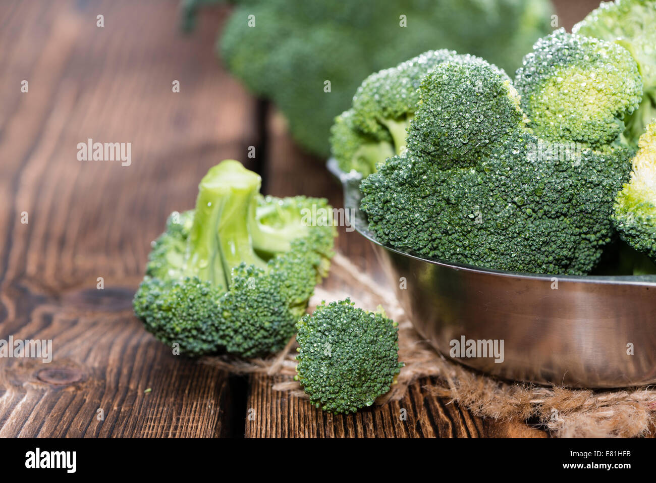 Materie Broccoli (dettagliate di close-up shot) su sfondo di legno Foto Stock