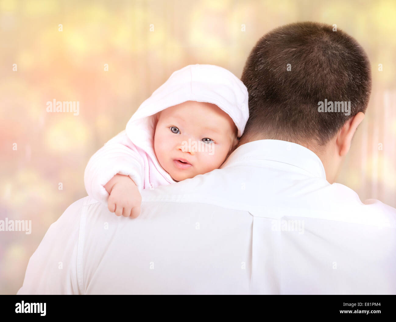 Ritratto di padre con il bambino a casa, lato posteriore di felice giovani daddy holding neonato su mani sulla sfocatura dello sfondo bokeh di fondo Foto Stock