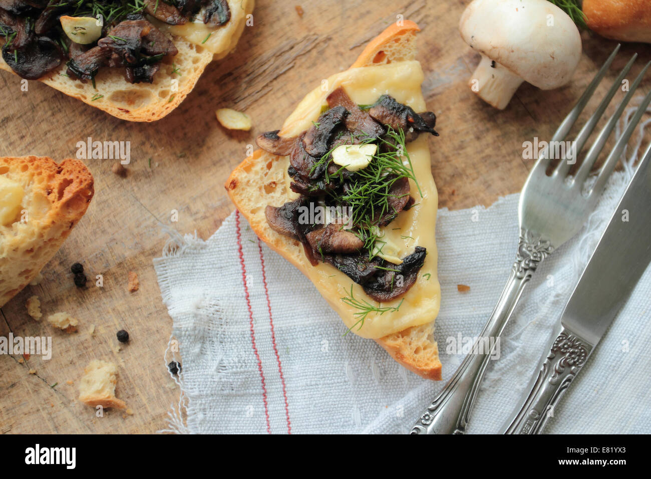 Pane tostato con funghi freschi, formaggio, aglio e finocchio Foto Stock