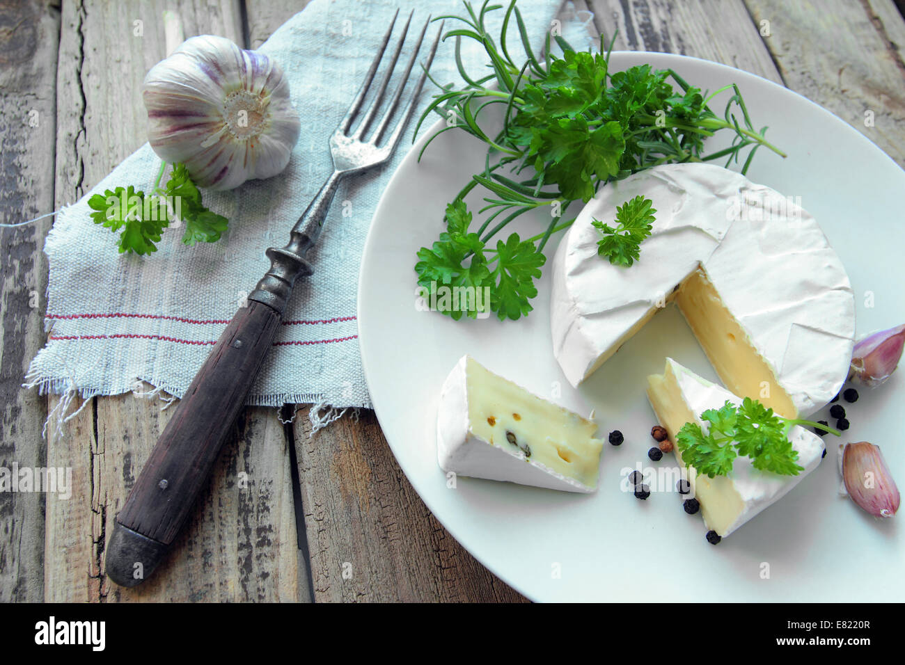 Fresco formaggio camembert con erbe su una piastra bianca con forca Foto Stock