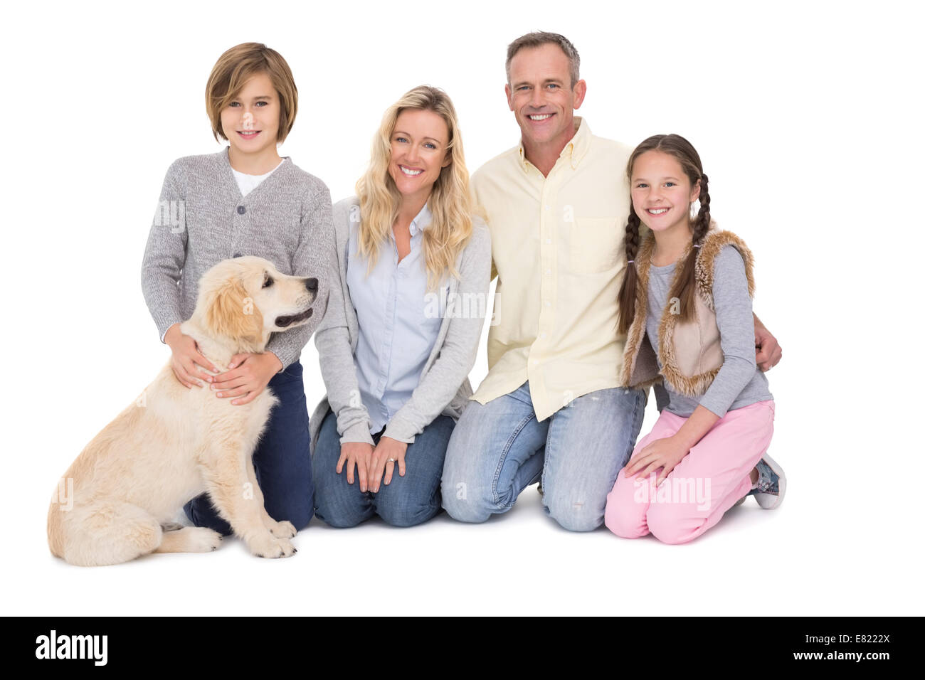 Famiglia con il loro cane in posa e sorridente in telecamera insieme Foto Stock
