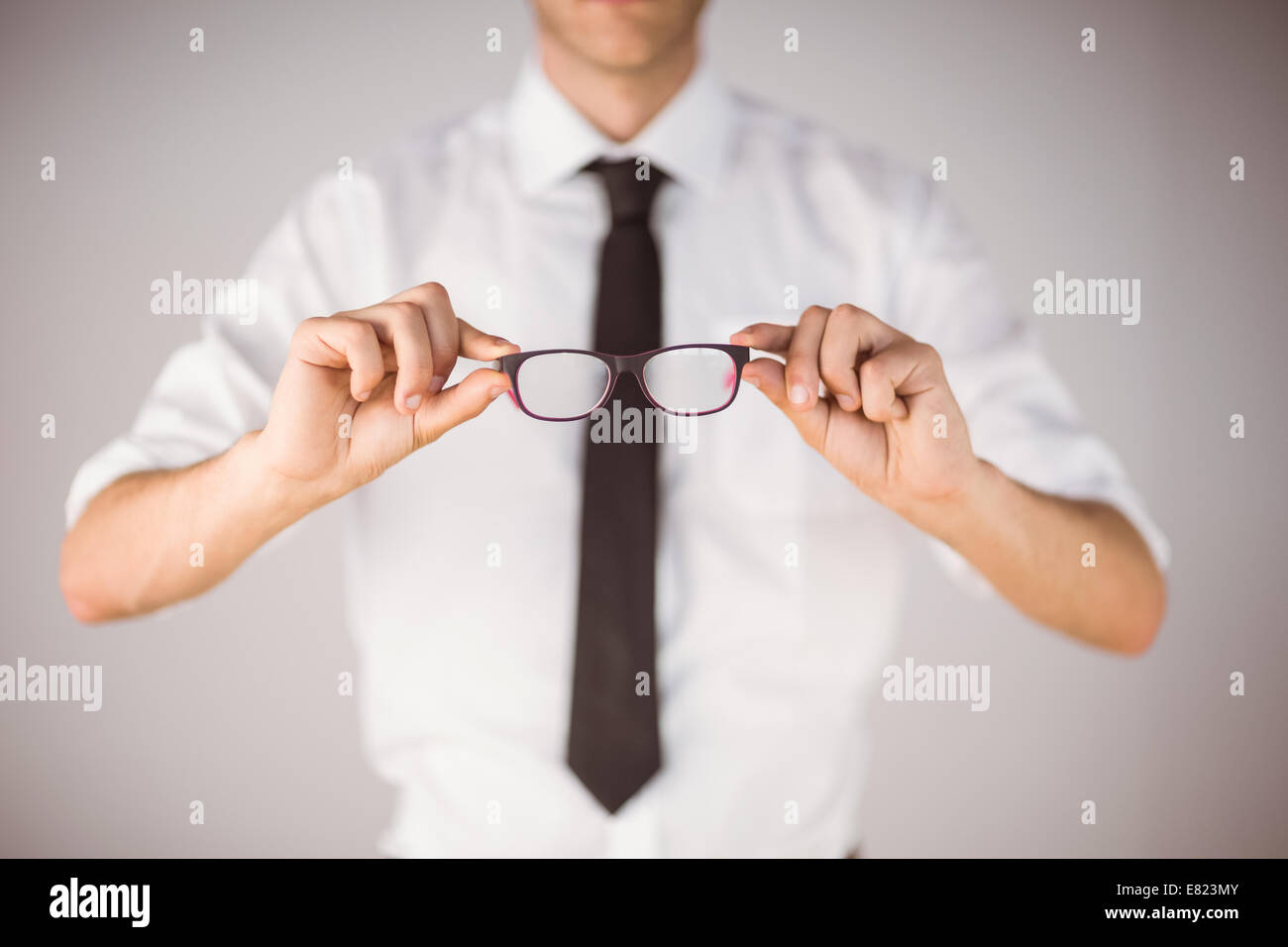Imprenditore tenendo gli occhiali da lettura Foto Stock