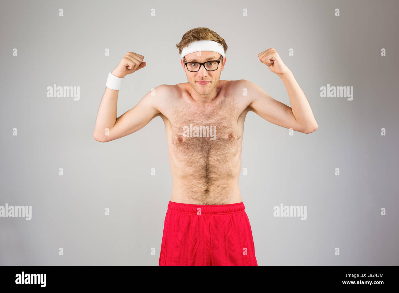 Geeky shirtless hipster flessione bicipite Foto Stock