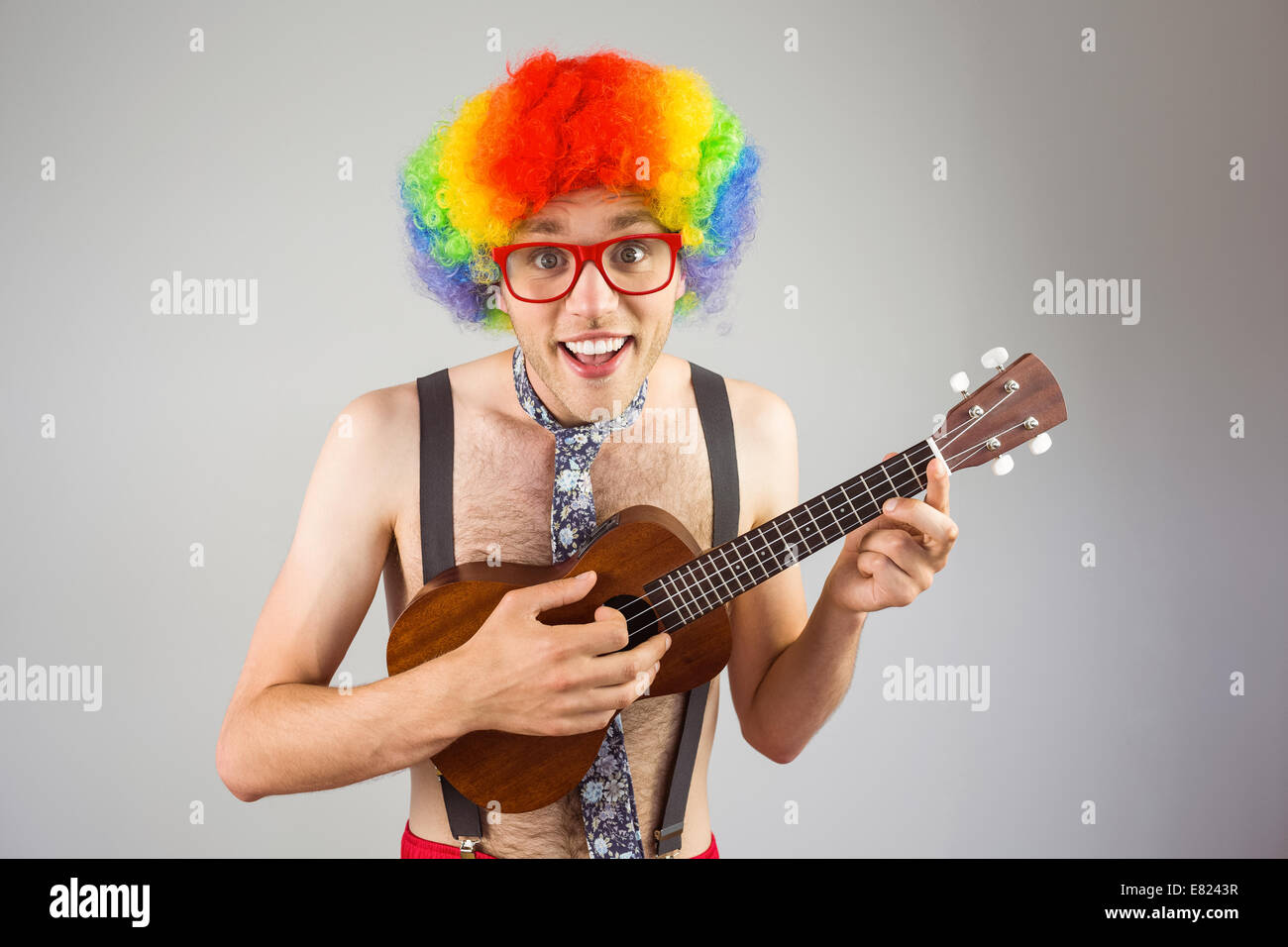 Geeky hipster afro parrucca arcobaleno a suonare la chitarra Foto Stock