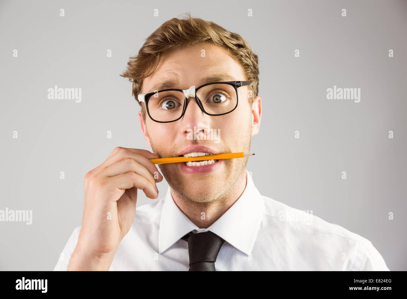 Geeky imprenditore mordere una matita Foto Stock