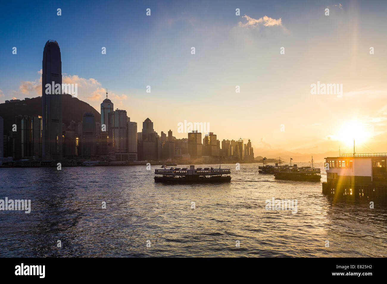 Tramonto sul Victoria Harbour e la star ferries in Hong Kong Foto Stock