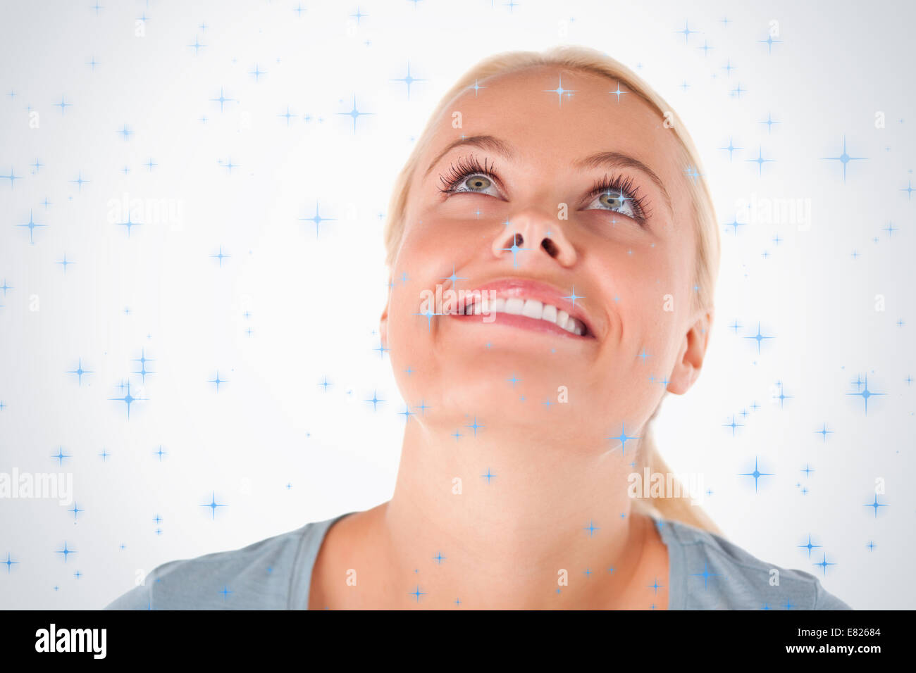 Sorridente donna bionda guardando il soffitto Foto Stock