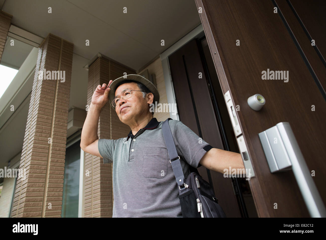 Un uomo in piedi alla sua porta anteriore. Foto Stock