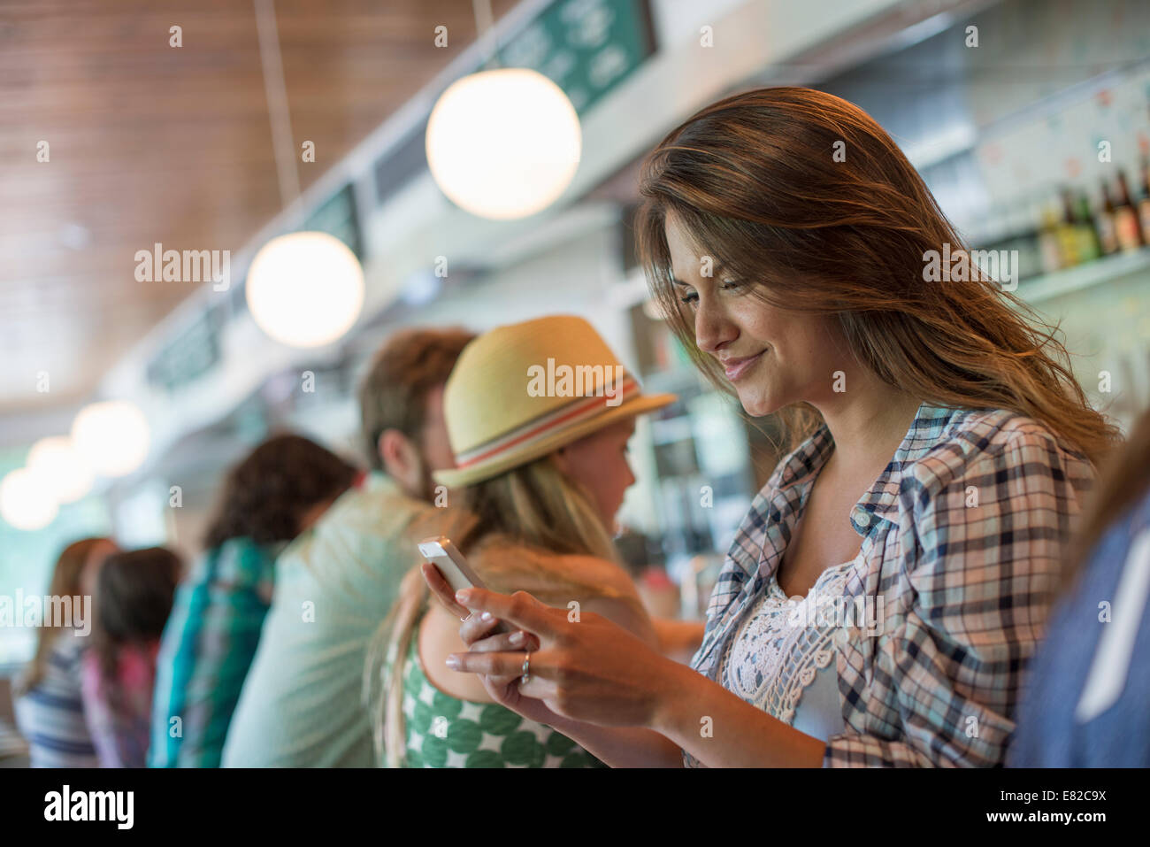 Una donna in un diner, guardando il suo telefono cellulare. Foto Stock