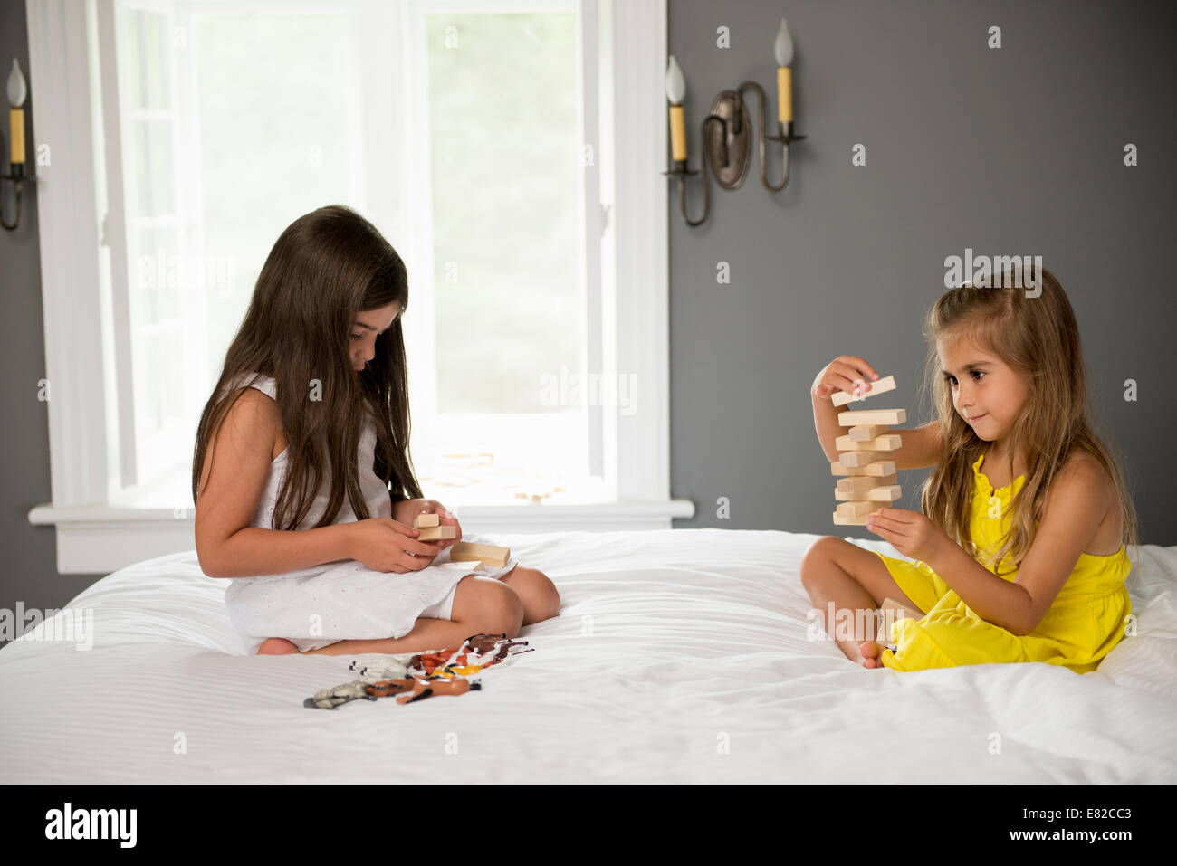 Due ragazze seduto su un letto a giocare insieme. Foto Stock
