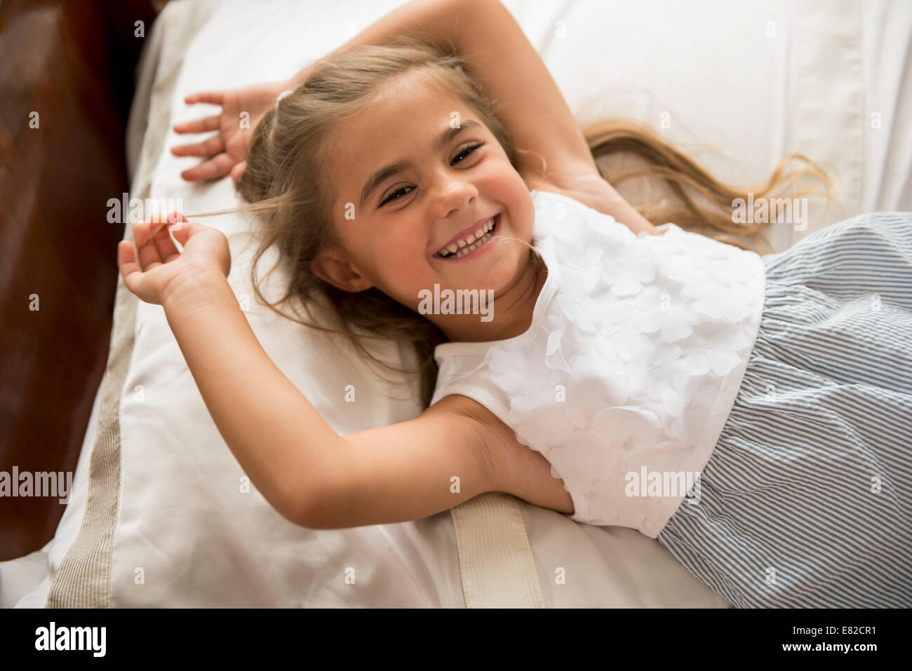 Una giovane ragazza guardando la telecamera, sorridente. Foto Stock