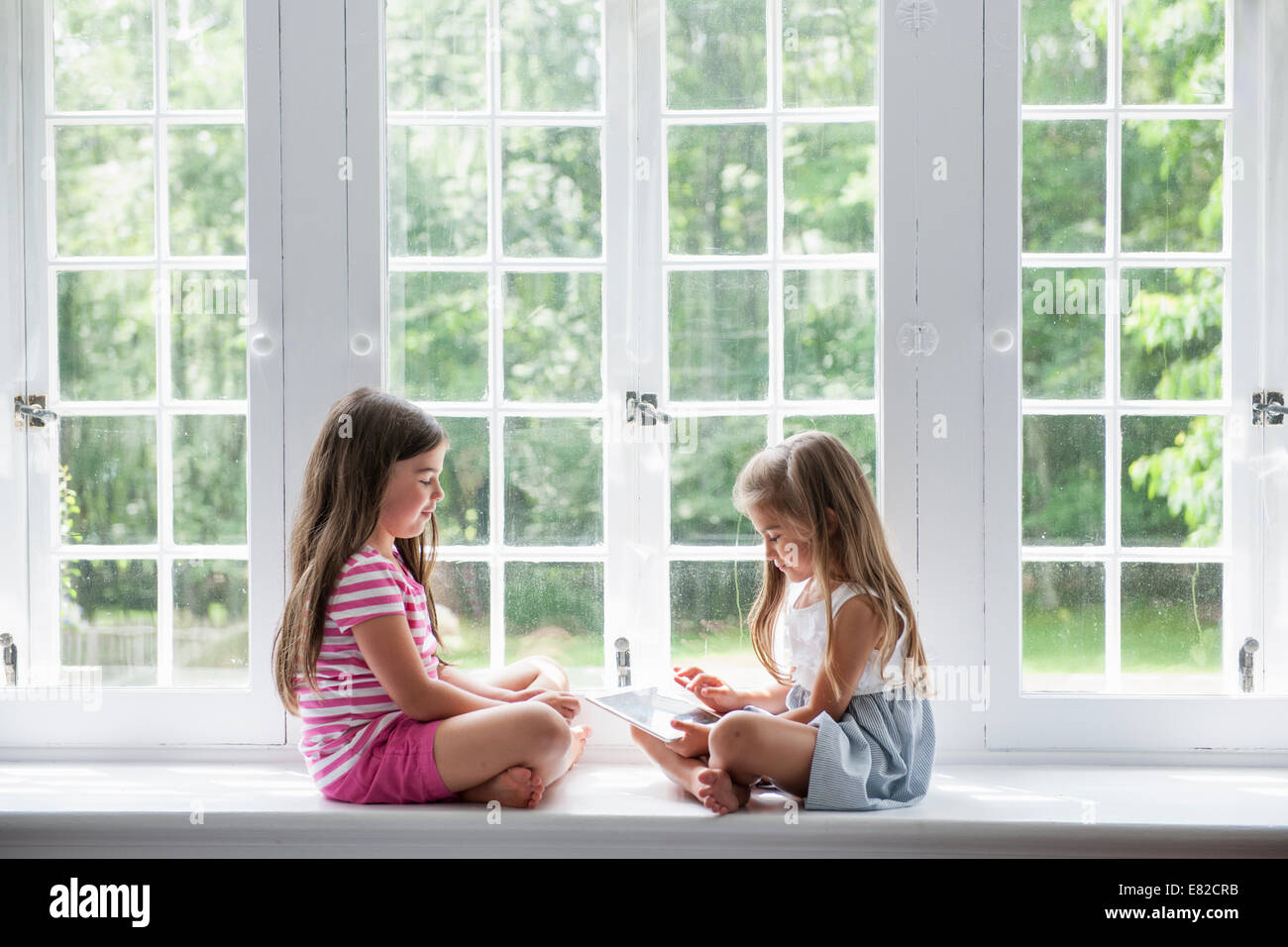 Due ragazze giocando, la condivisione di una tavoletta digitale. Foto Stock