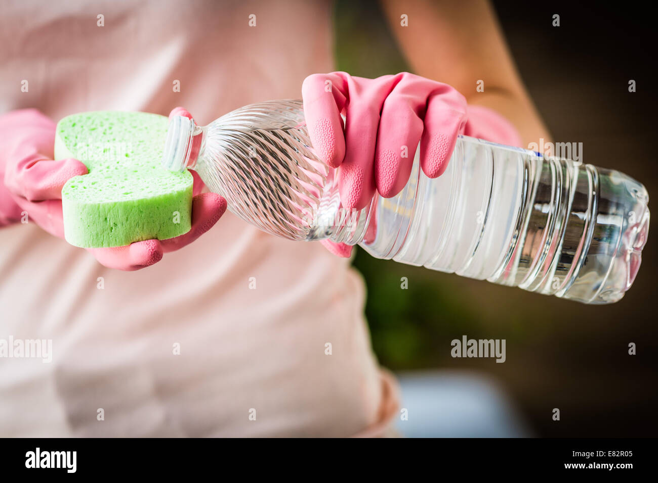 Donna con aceto bianco per pulire. Foto Stock