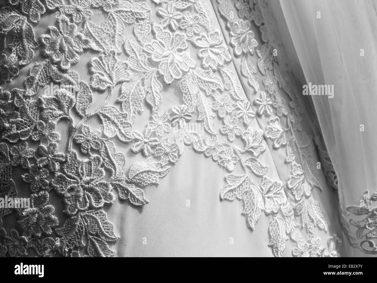 Dettaglio di abiti da sposa con velo. La texture del vestito da sposa con fiori ricamati. Immagine in bianco e nero Foto Stock