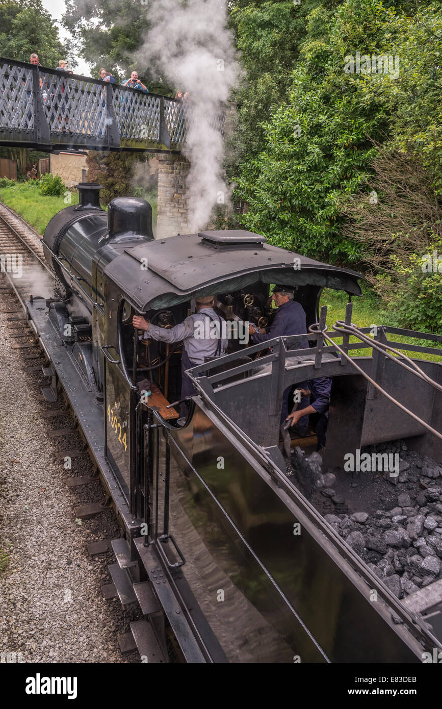 LMS Classe 4F 0-6-0 "Big merci' motore trasporta un treno passeggeri a Haworth stazione sul Keighley e Worth Valley Railway. La KWR Foto Stock