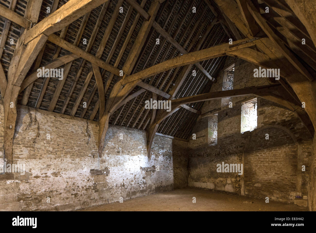 L'interno del XIV secolo sala Tithe Barn con il suo uncino telaio opera di legname, East Street Lacock, Wiltshire, Inghilterra, Regno Unito Foto Stock