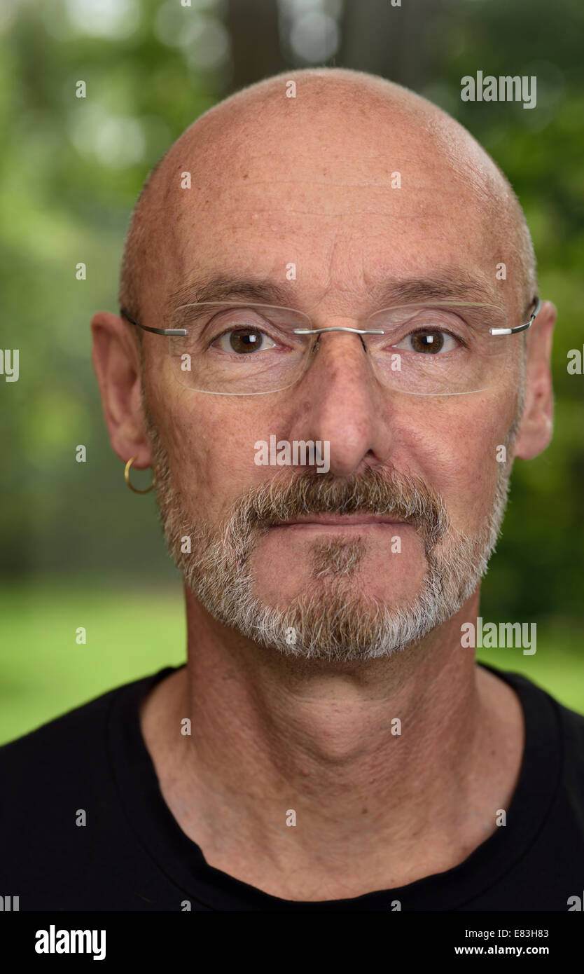 Faccia di pensionati uomo calvo circa 60 anni con la barba e i bicchieri in foresta verde cortile Foto Stock