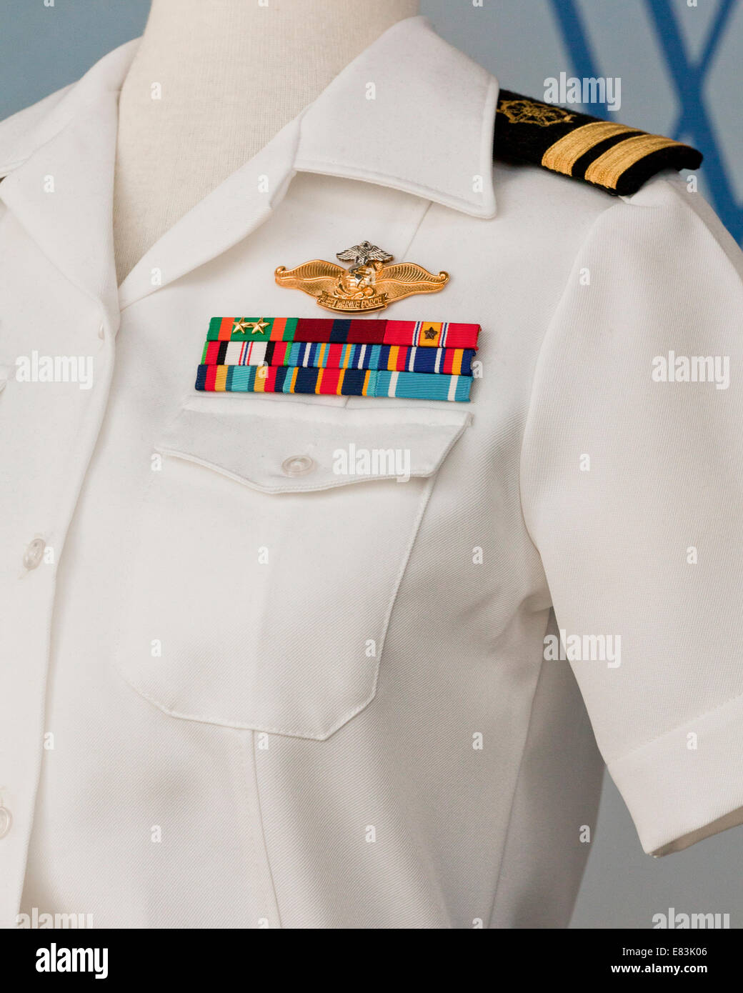 US Navy funzionario femmina estate bianco uniforme di servizio che mostra la scheda di spallamento e nastri di aggiudicazione Foto Stock