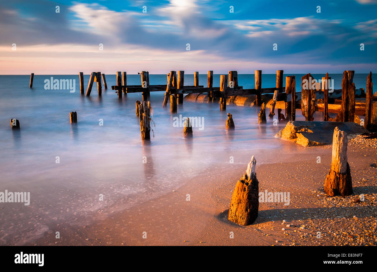 Una lunga esposizione al tramonto di pier palificazioni in la baia del Delaware al Sunset Beach, Cape May, New Jersey. Foto Stock