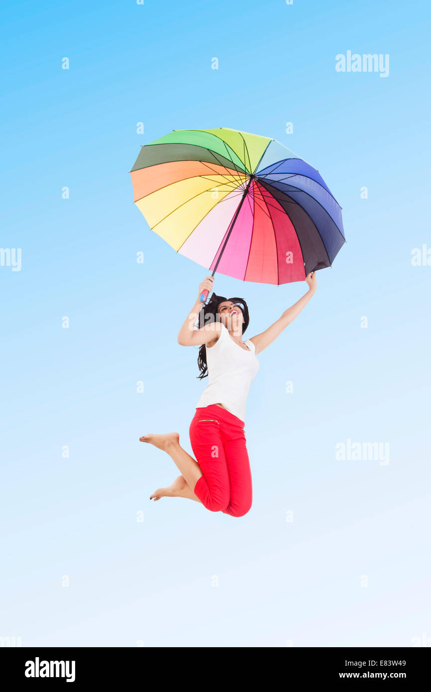 Ragazza indiana Park Jumping con ombrellone Foto Stock