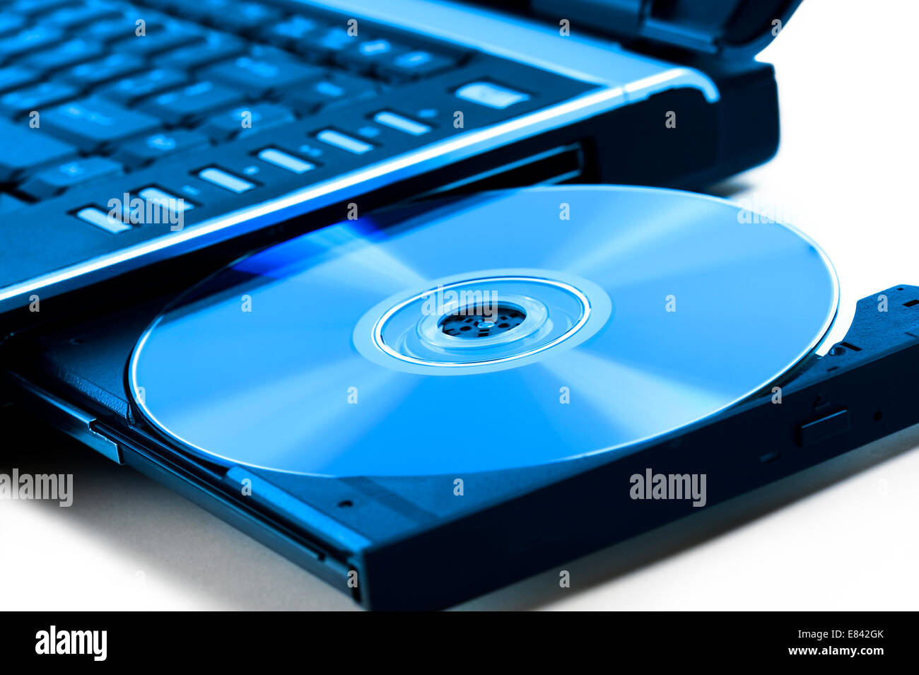 Il compact disk inserito su unità per notebook, su sfondo bianco Foto Stock