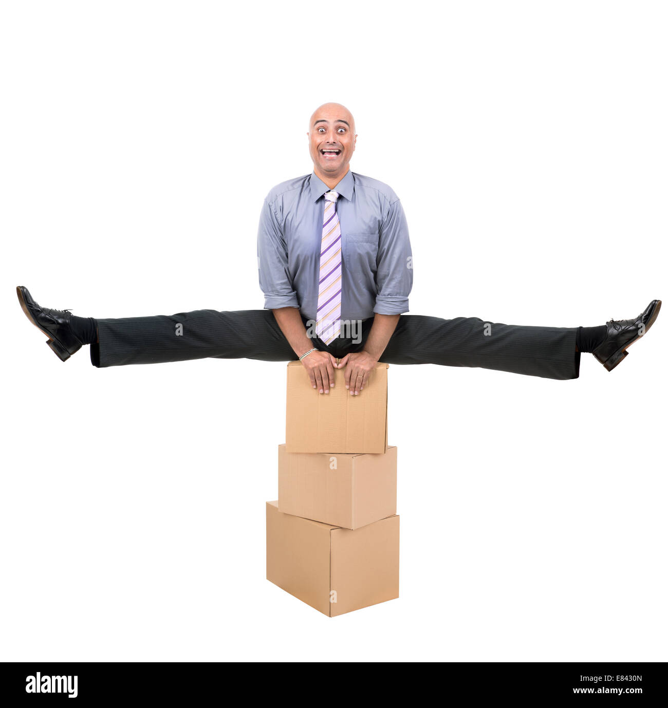 Imprenditore a fare gli esercizi su una pila di scatole di cartone Foto Stock