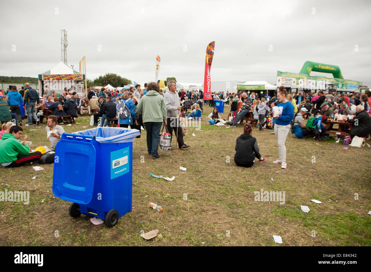 Il cestino e spazzatura tra una folla di persone in un festival in un campo Foto Stock