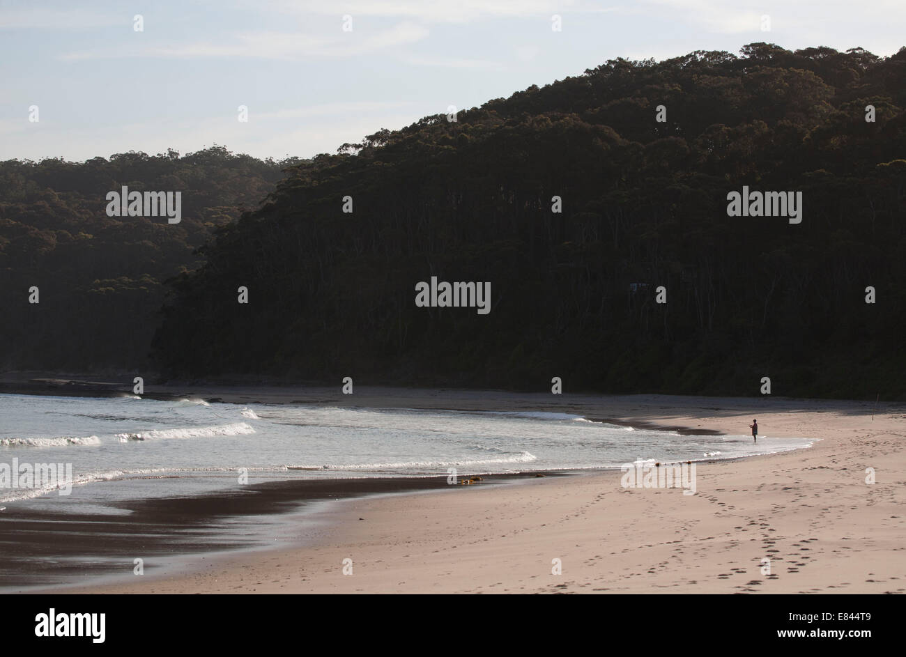 Un pescatore solitario sulle rive sabbiose della spiaggia di ciottoli - Murramarang National Park South Coast NSW Australia Foto Stock