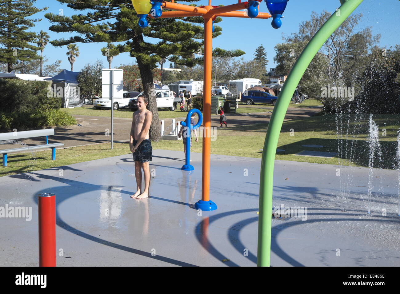 Giovane ragazzo il raffreddamento in acqua park a sydney holiday park in primavera tempo,l'australia Foto Stock