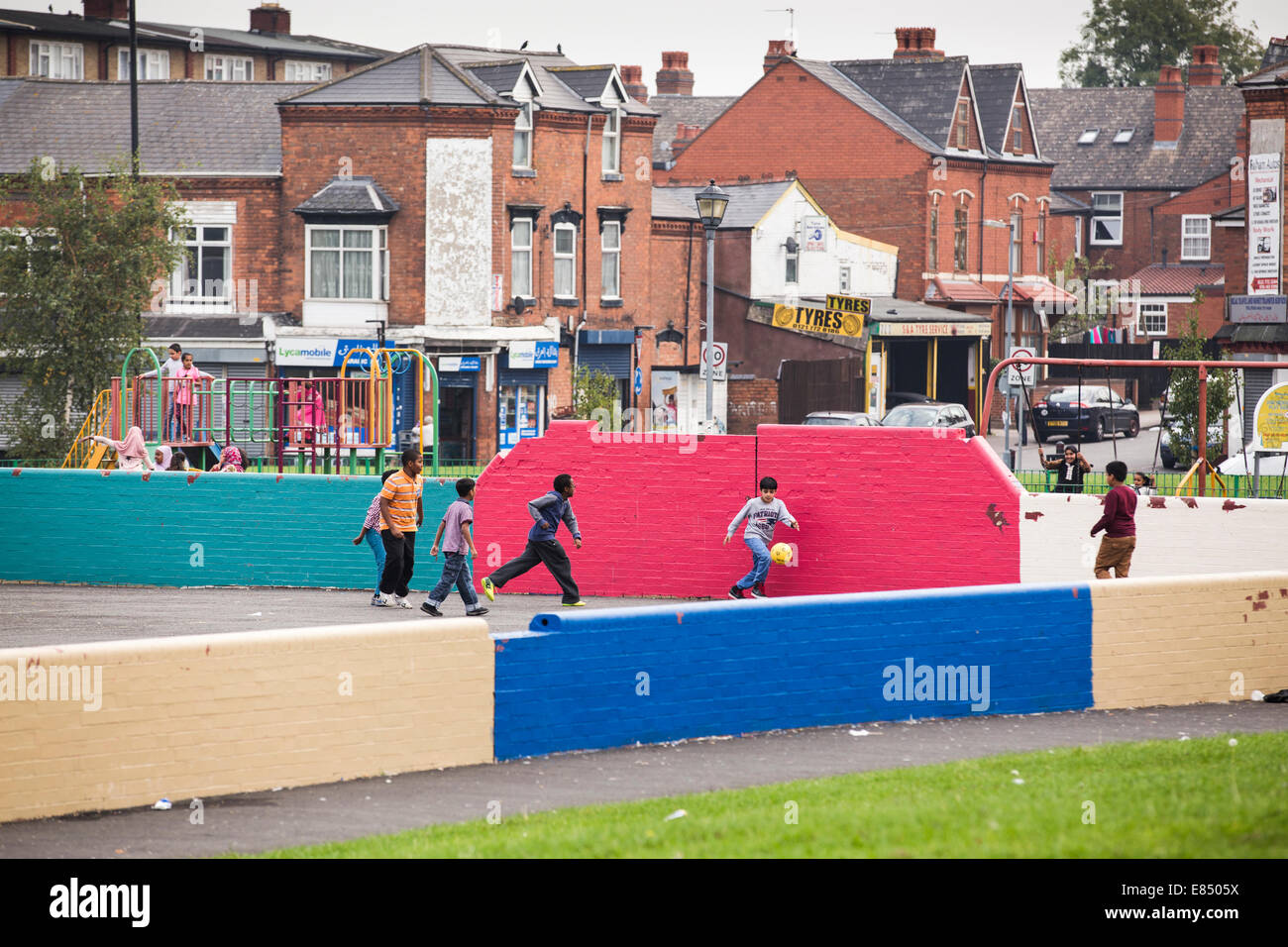I bambini che giocano a calcio in un parco a Sparkhill, Birmingham, Regno Unito Foto Stock