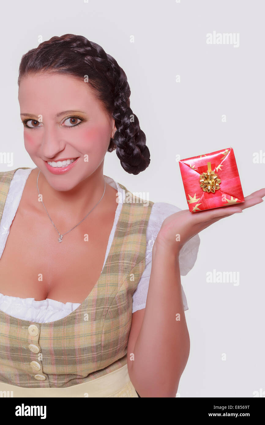 Giovane donna bavarese in dirndl con un piccolo regalo sul tuo Palm. Foto Stock