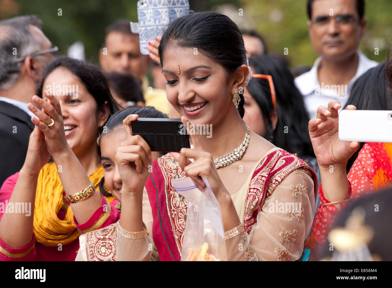 Donna indiana di nastratura video un evento utilizzando smart phone - USA Foto Stock