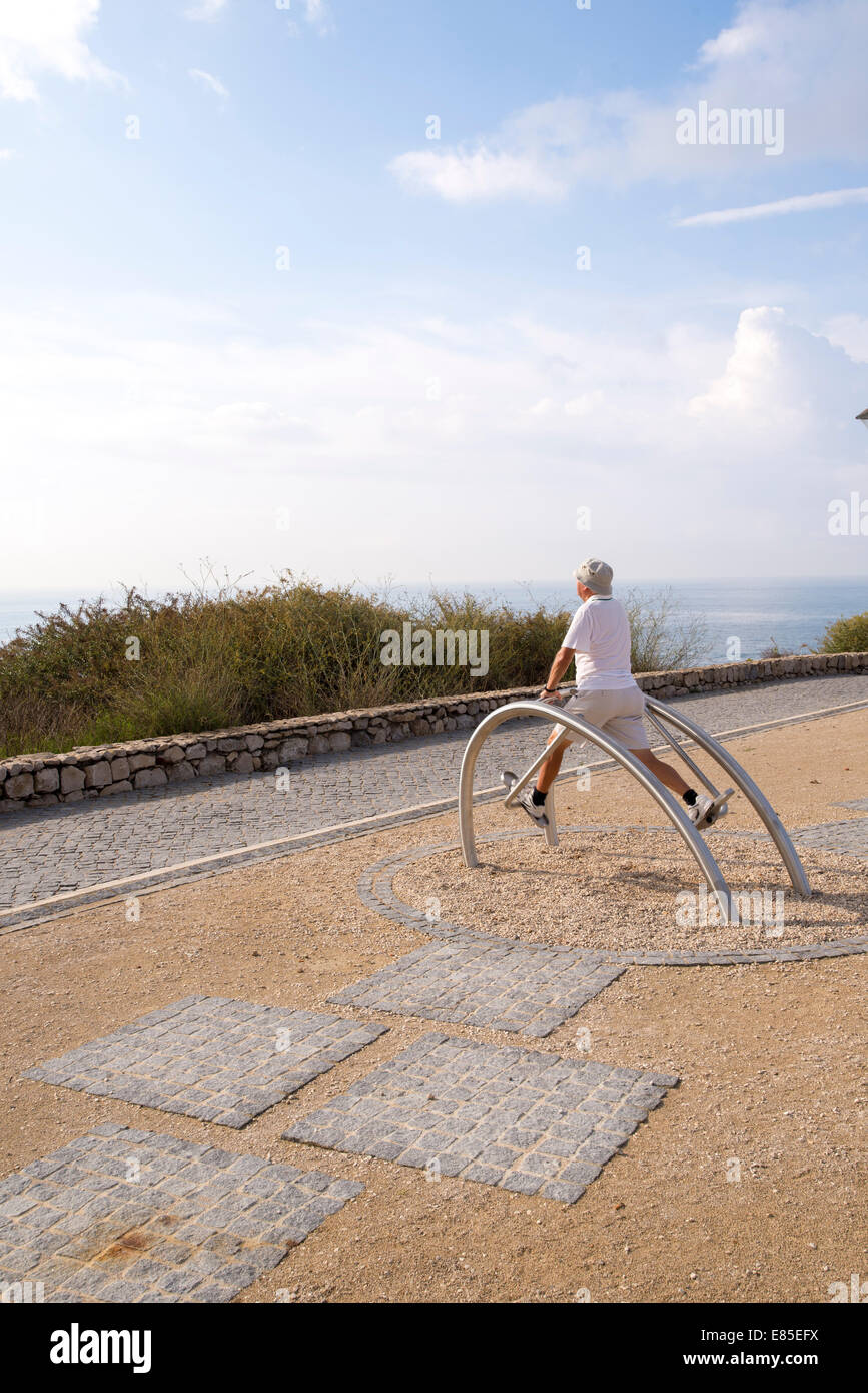 Senior uomo esercitando su apparecchiature per uso esterno. Foto Stock