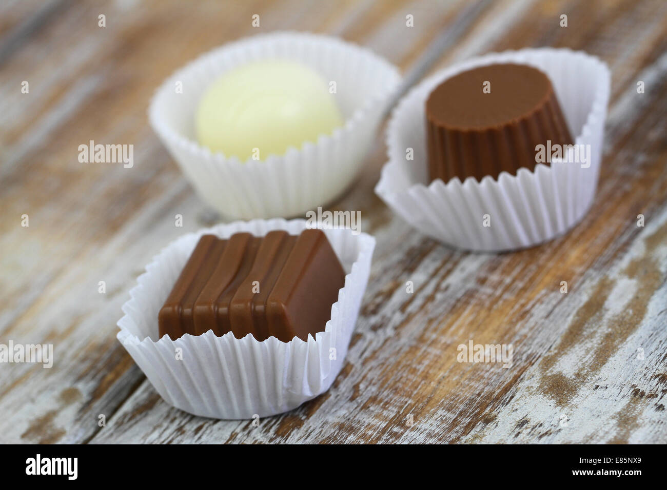 Cioccolatini assortiti su una superficie di legno Foto Stock