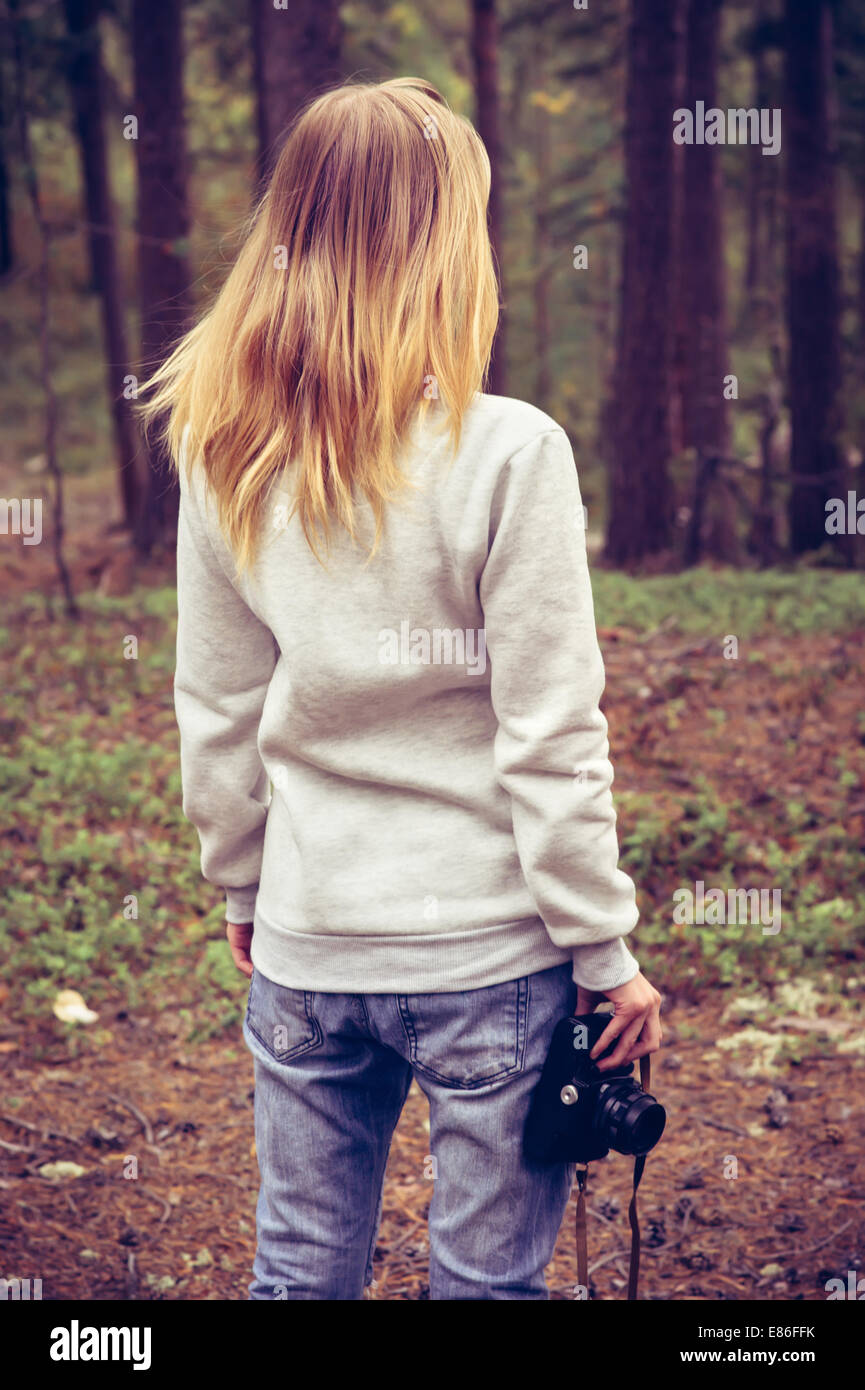 Giovane donna a piedi con retrò fotocamera foto Outdoor Lifestyle natura foresta sullo sfondo Foto Stock