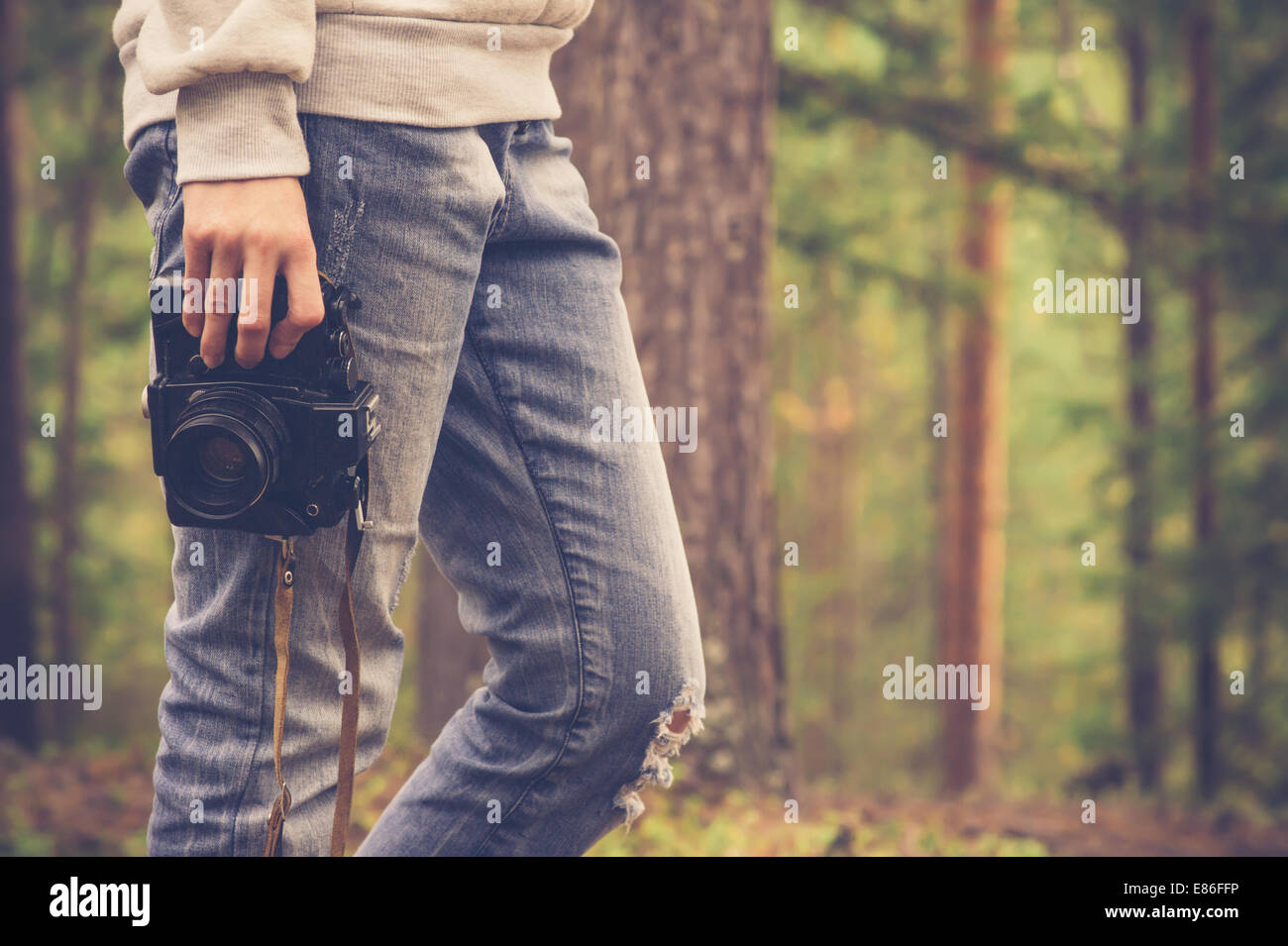 Giovane donna a piedi con retrò fotocamera foto Outdoor Lifestyle natura foresta sullo sfondo Foto Stock