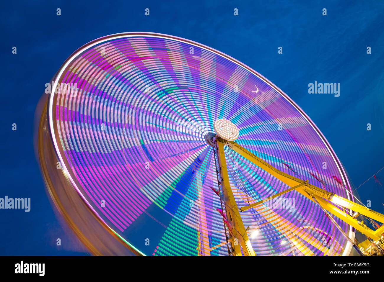 Un colorato ruota panoramica Ferris prese con una lunga esposizione che mostra i diversi colori Foto Stock