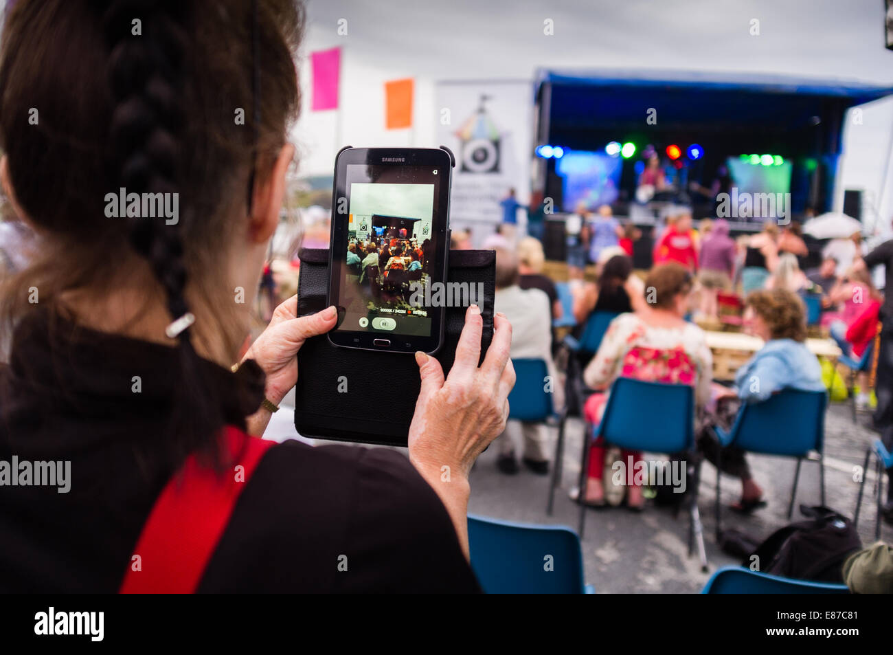 Una donna la registrazione di una band di eseguire la riproduzione a un festival di musica sul suo Samsung mobile smart phone UK Foto Stock