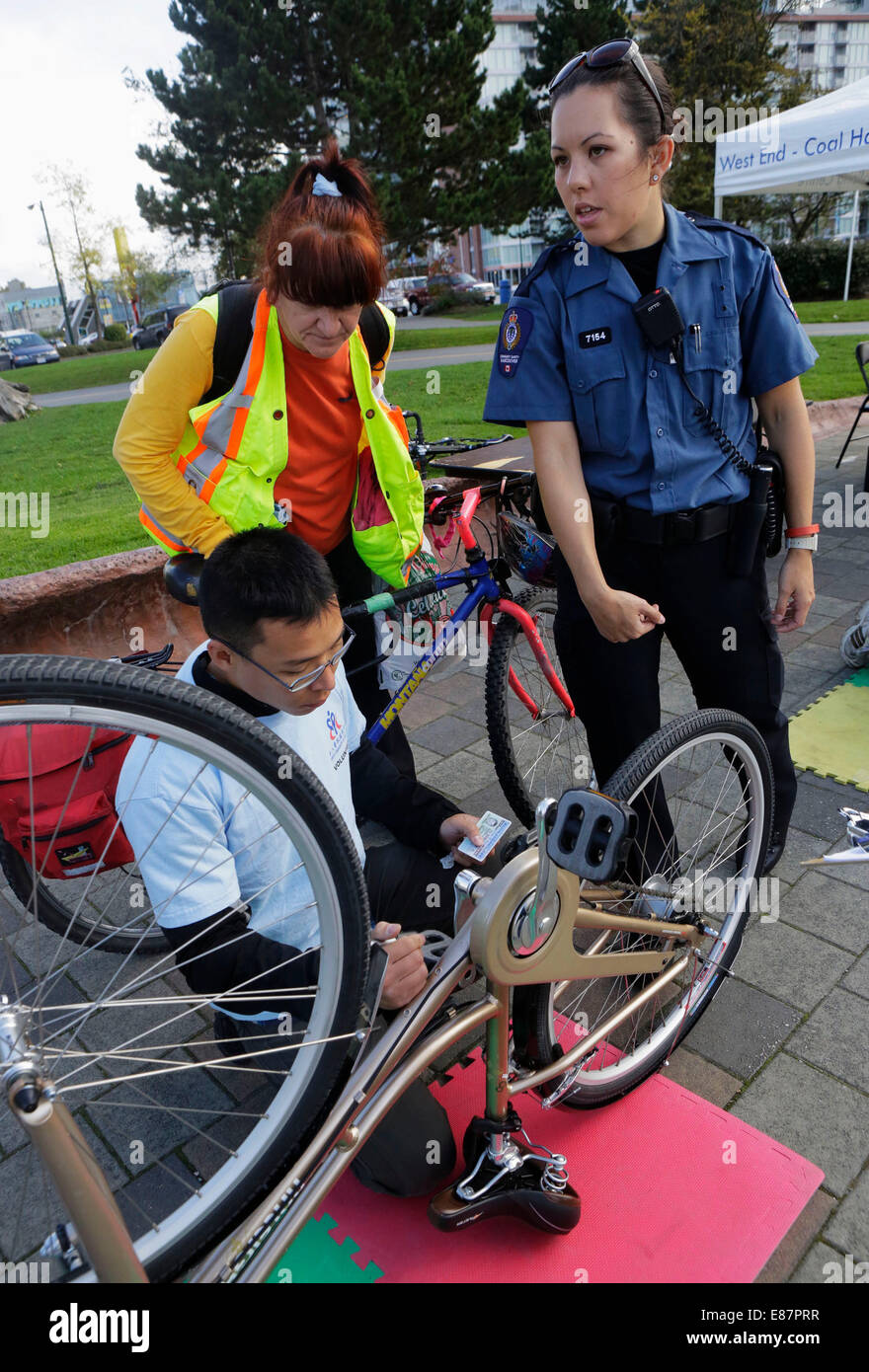 Vancouver, Canada. Il 2 ottobre, 2014. Un volontario incisione di un numero di identificazione alla parte di fondo di una bicicletta a False Creek comunità. Le biciclette con inciso del proprietario i numeri di identificazione di renderlo meno di un bersaglio di ladri e più facili da recuperare quando la bicicletta viene rubato. La polizia recupera circa 1.500 biciclette rubati ogni anno e quasi la metà di loro non è in grado di restituire ai proprietari come le biciclette non hanno le identificazioni di a. Credito: Xinhua/Alamy Live News Foto Stock