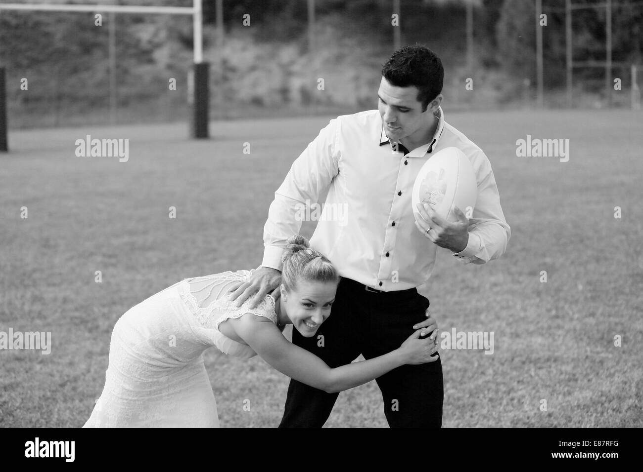 Cestino abiti sposa e lo sposo giocando a rugby Foto Stock