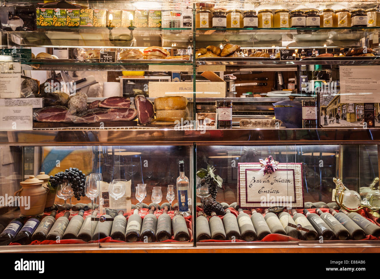 Alimenti e bevande con vecchie bottiglie di vino in polvere visualizzati nella vetrina di un italiano di bar caffetteria in Montalcino Italia Foto Stock