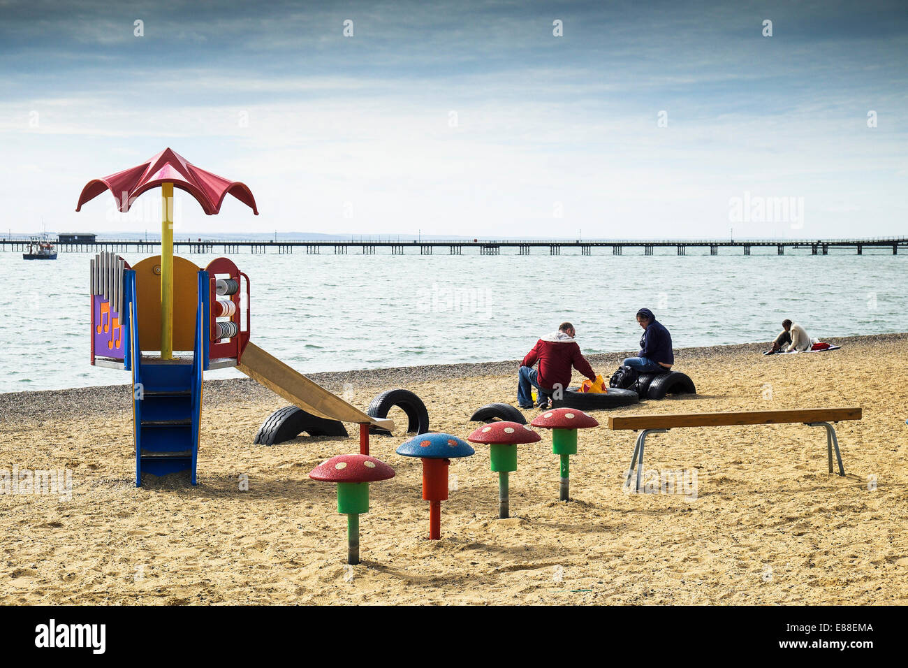 Una famiglia seduta sul Giubileo Beach a Southend in Essex. Foto Stock