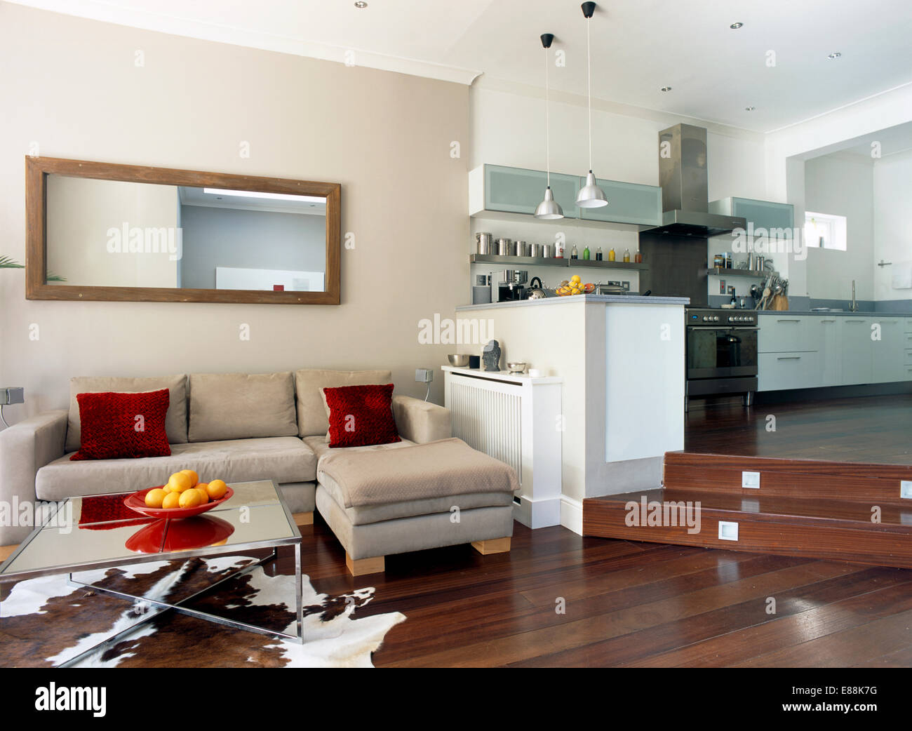 Specchio rettangolare sopra camoscio beige divano componibile in un livello  diviso cucina soggiorno con set di illuminazione in passi Foto stock - Alamy