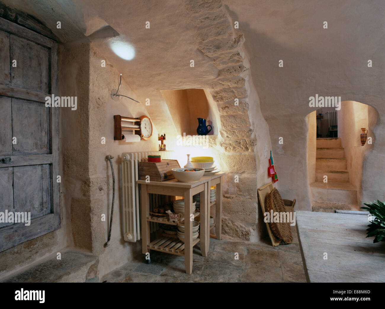 Stoviglie su rustiche mensole di legno nel seminterrato cucina con pietra  grezza pareti Foto stock - Alamy